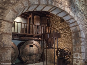 Detalle parcial del interior de una bodega tradicional ya en desuso en Biniagual, en primer término se aprecia una prensa mecánica de uva.